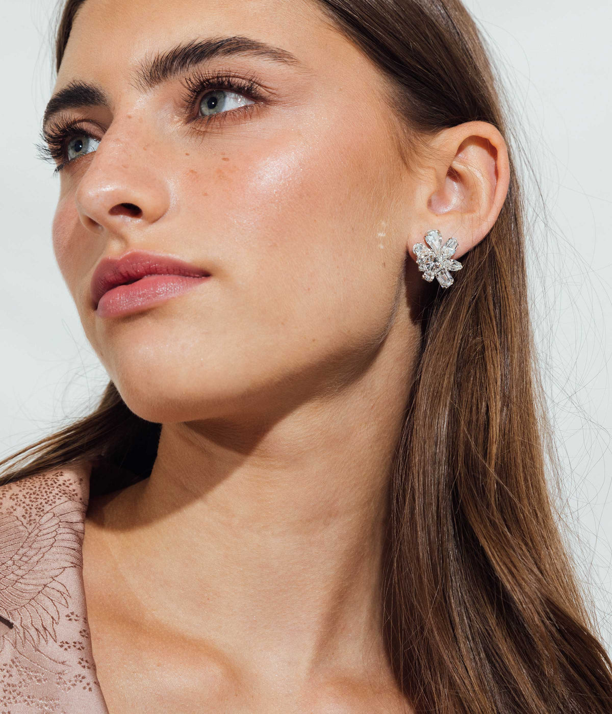 Close-up view of Birdie Earrings in Crystal showcasing hand-set crystal stones on a model with a neutral background
