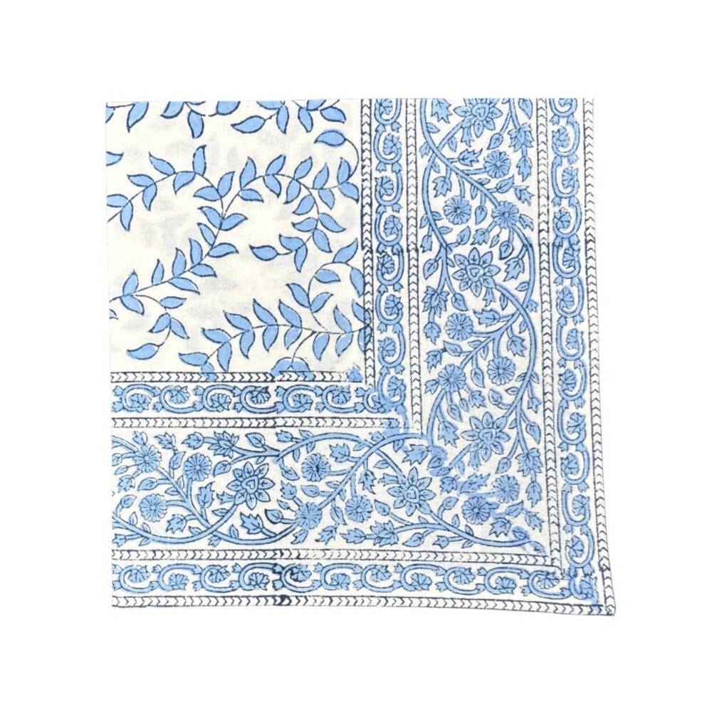 Close-up of Blue Leaves napkin showcasing blue block-printed leaf motif and floral border on white cotton
