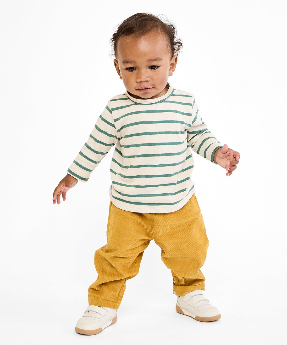 Front view of Bowie baby pant in mustard corduroy on toddler showing cuffable hem and elastic waist on white background