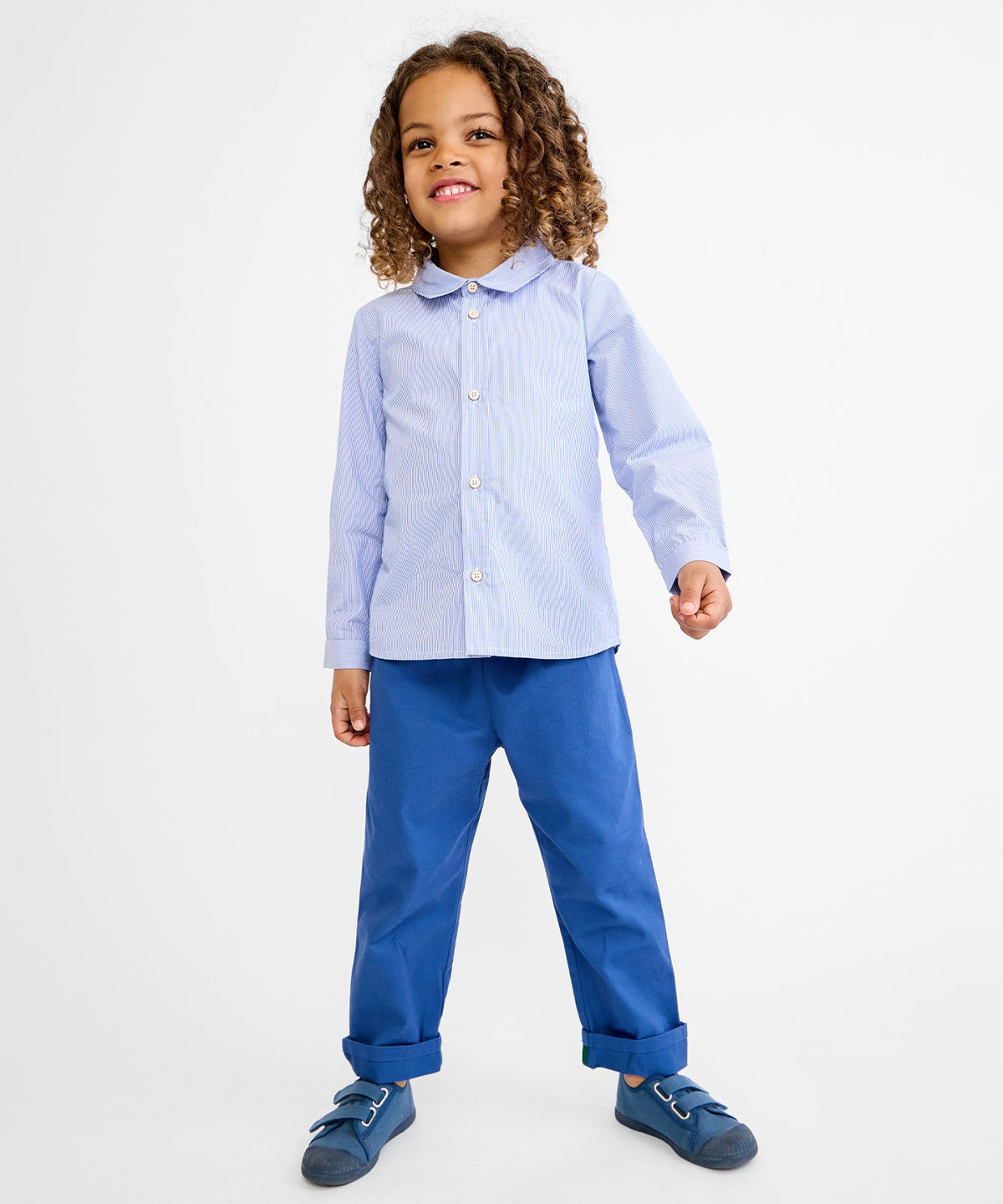 Front view of Bowie pant in blue on child model showing straight-leg fit and rolled cuffs on white background