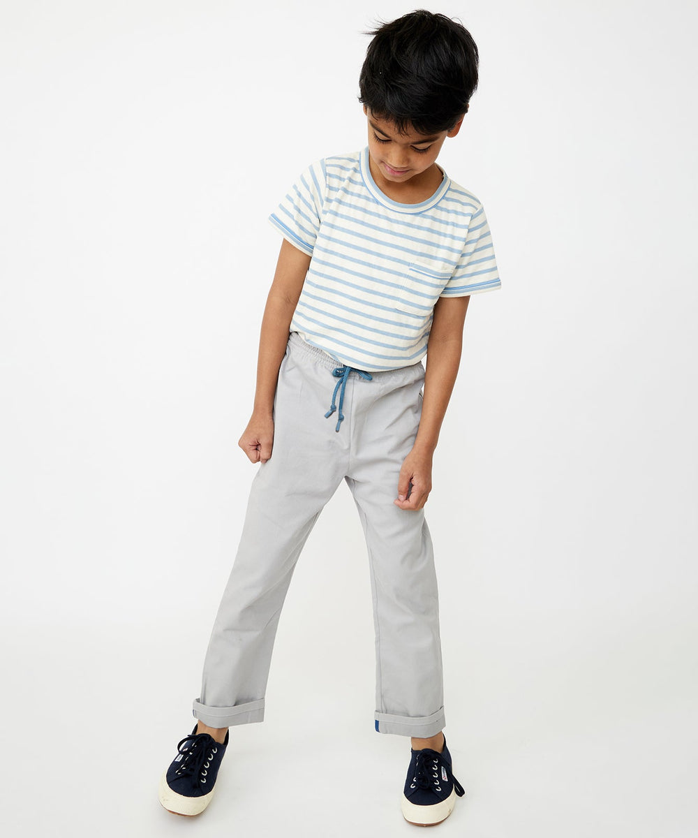 Front view of Bowie Pant in Cloud on child model, light-gray pull-on pants with blue drawcord and cuffed hem