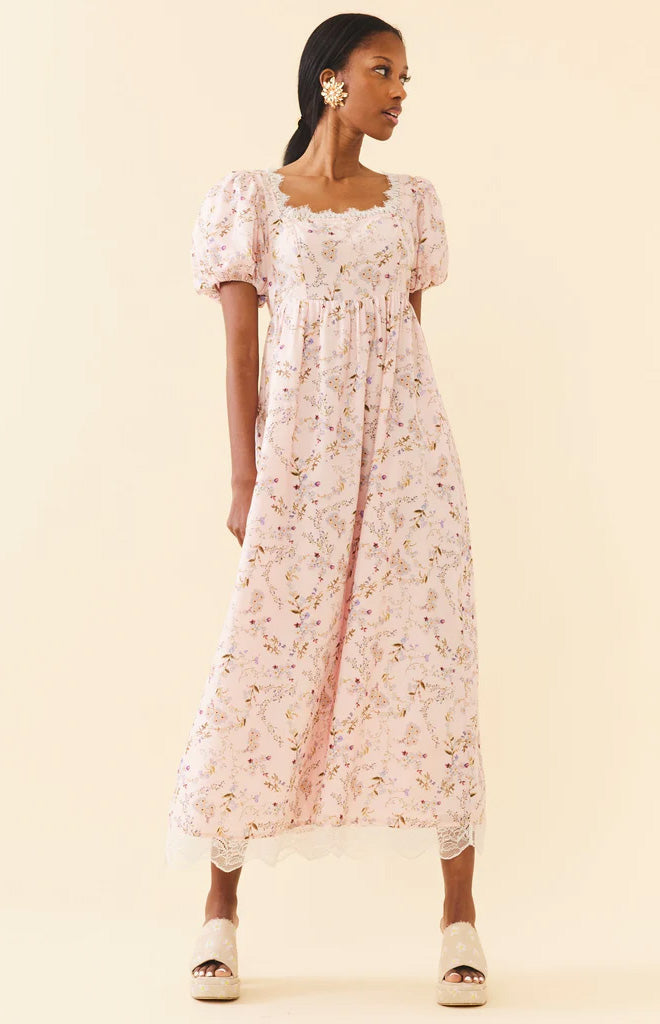 Front view of Bridgerton Maxi showcasing its soft blush floral print, empire waist, and crochet lace hem on a model