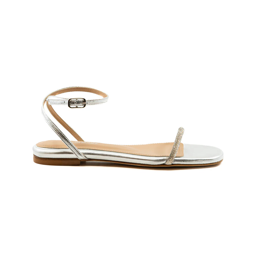 Side view of Brook Flat silver sandal showcasing crystal-embellished toe strap and ankle buckle on white background