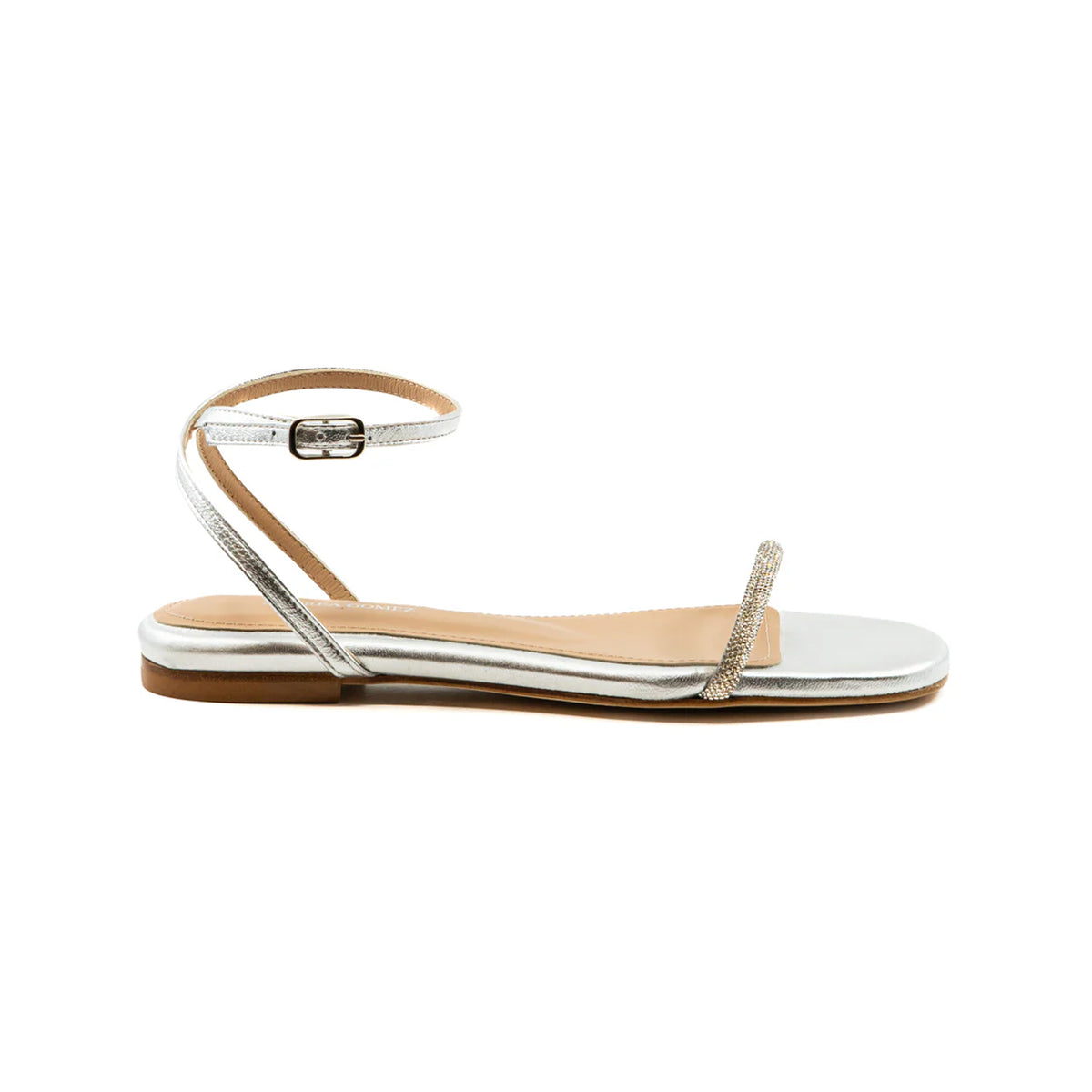 Side view of Brook Flat silver sandal showcasing crystal-embellished toe strap and ankle buckle on white background