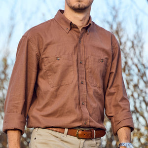 Man wearing Tom Beckbe Dixon Brushed Cotton Twill Shirt, tan pants, and brown belt, standing outdoors.