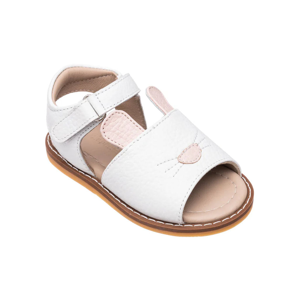 Angled view of white toddler sandal with embroidered bunny face and pink ears, adjustable ankle strap, open toe and tan sole