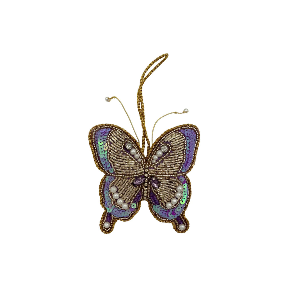 Front view of purple butterfly ornament with hand-stitched beads, pearl antennae, iridescent sequins on white background