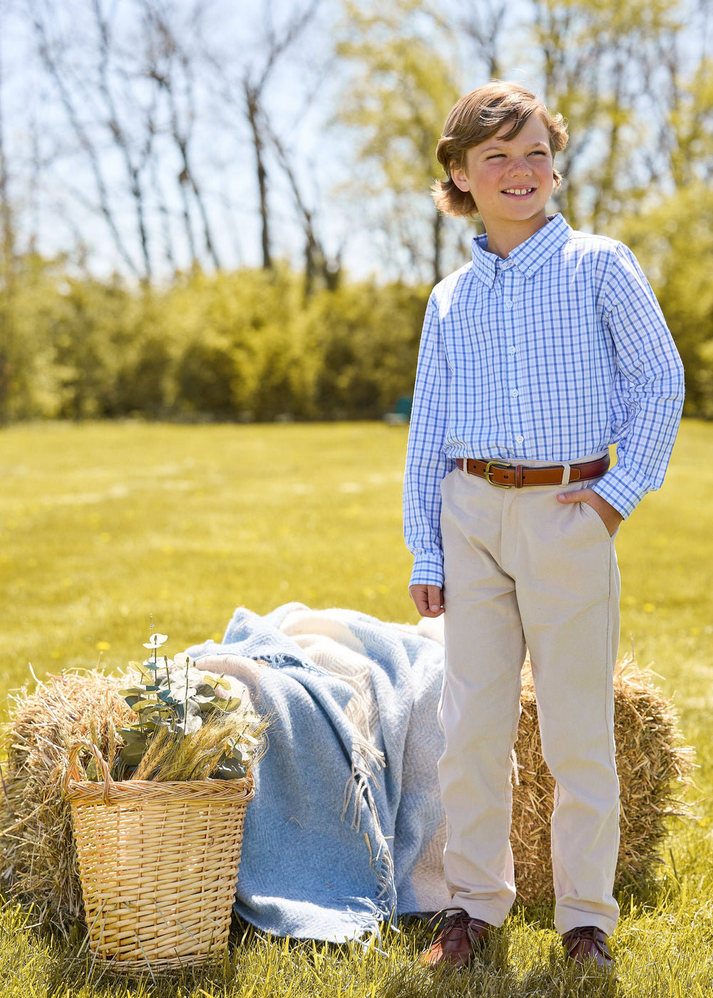 Three-quarter view of Button Down Shirt in Woodberry Plaid on a boy, showing blue-white plaid and modern fit in an outdoor field