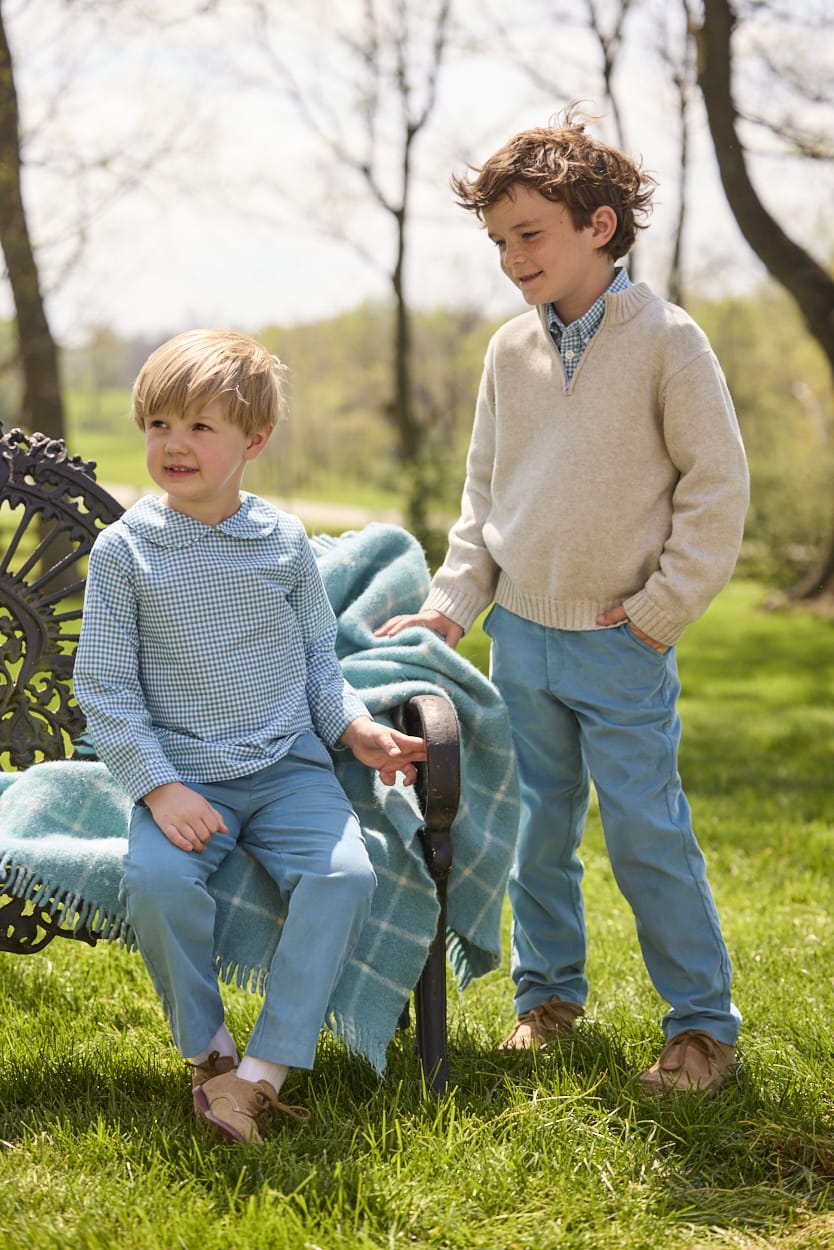 Little English traditional children's clothing.  Classic long sleeve peter pan shirt in blue Alpine Gingham paired with blue Alpine Corduroy pull on pants for toddler boys.  Older boys gray quarter zip sweater layered over blue Alpine Gingham button down shirt and paired with blue Alpine Corduroy classic pants.