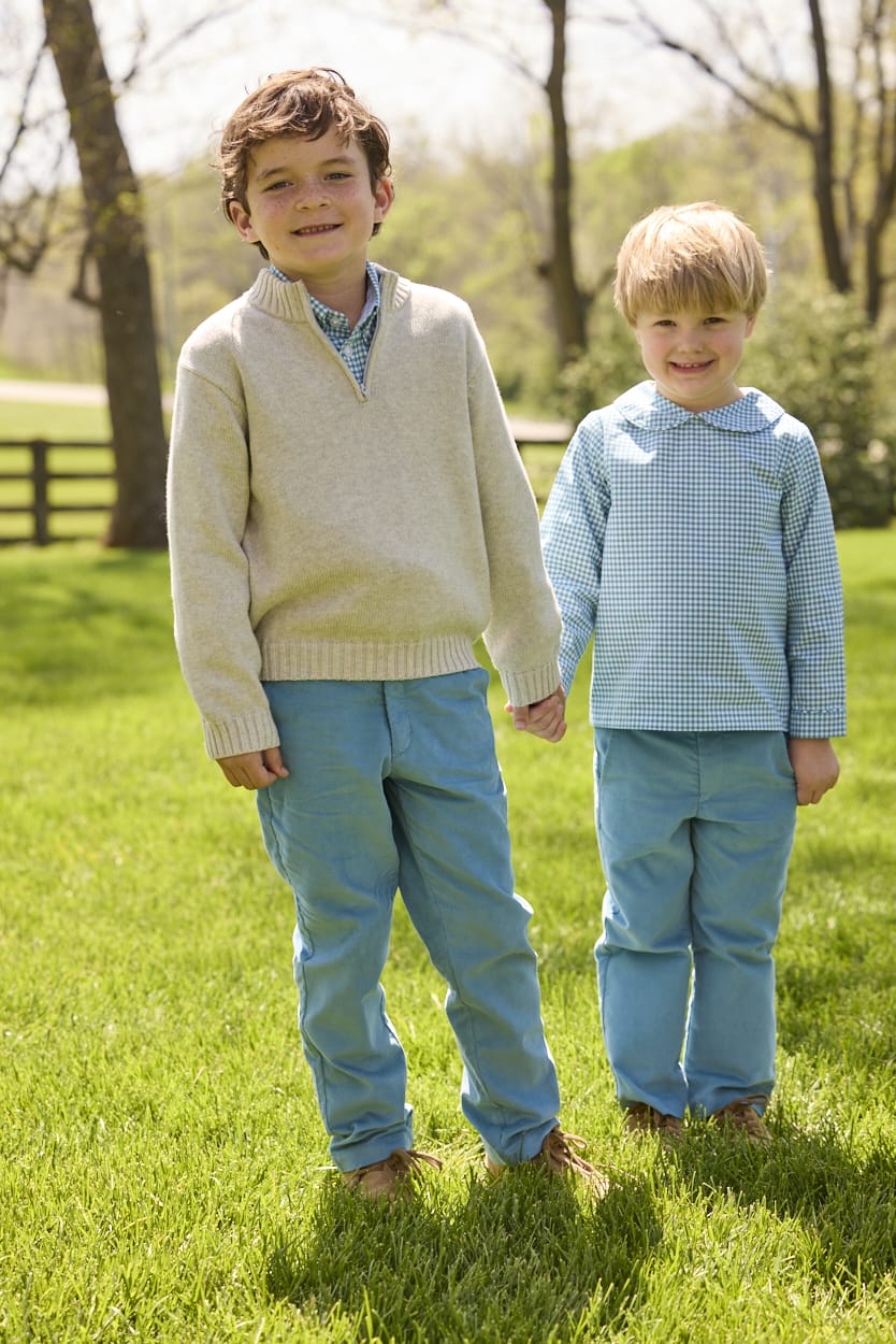 Little English traditional children's clothing.  Classic long sleeve peter pan shirt in blue Alpine Gingham paired with blue Alpine Corduroy pull on pants for toddler boys.  Older boys gray quarter zip sweater layered over blue Alpine Gingham button down shirt and paired with blue Alpine Corduroy classic pants.