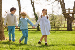 Little English traditional children's clothing.  Classic long sleeve peter pan shirt in blue Alpine Gingham paired with blue Alpine Corduroy pull on pants for toddler boys.  Older boys gray quarter zip sweater layered over blue Alpine Gingham button down shirt and paired with blue Alpine Corduroy classic pants. Ruffled collar long sleeve Bespoke Dress for little girls in blue and green Waterbury Floral