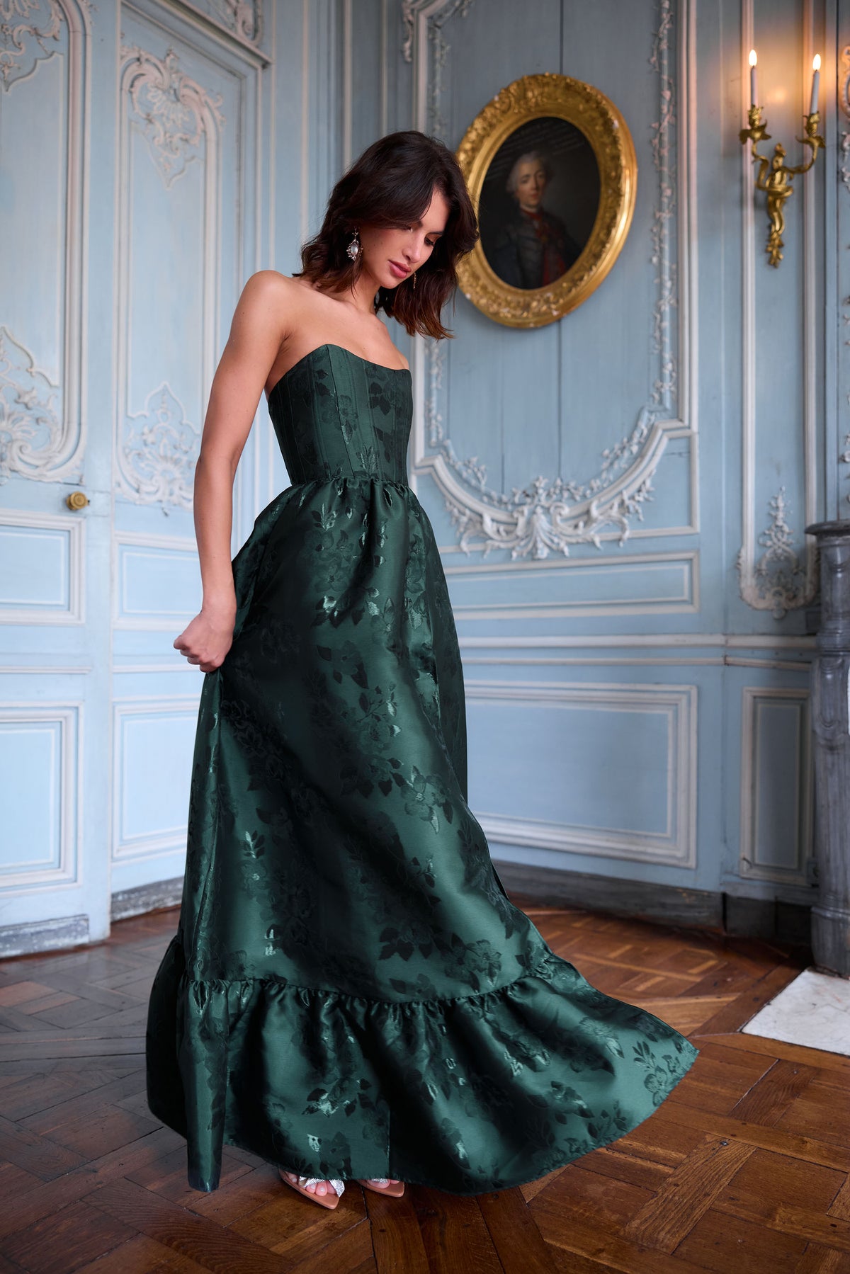 Front view of The Charlotte Dress in Emerald Baroque Floral showcasing its strapless bodice and gathered skirt in ornate room