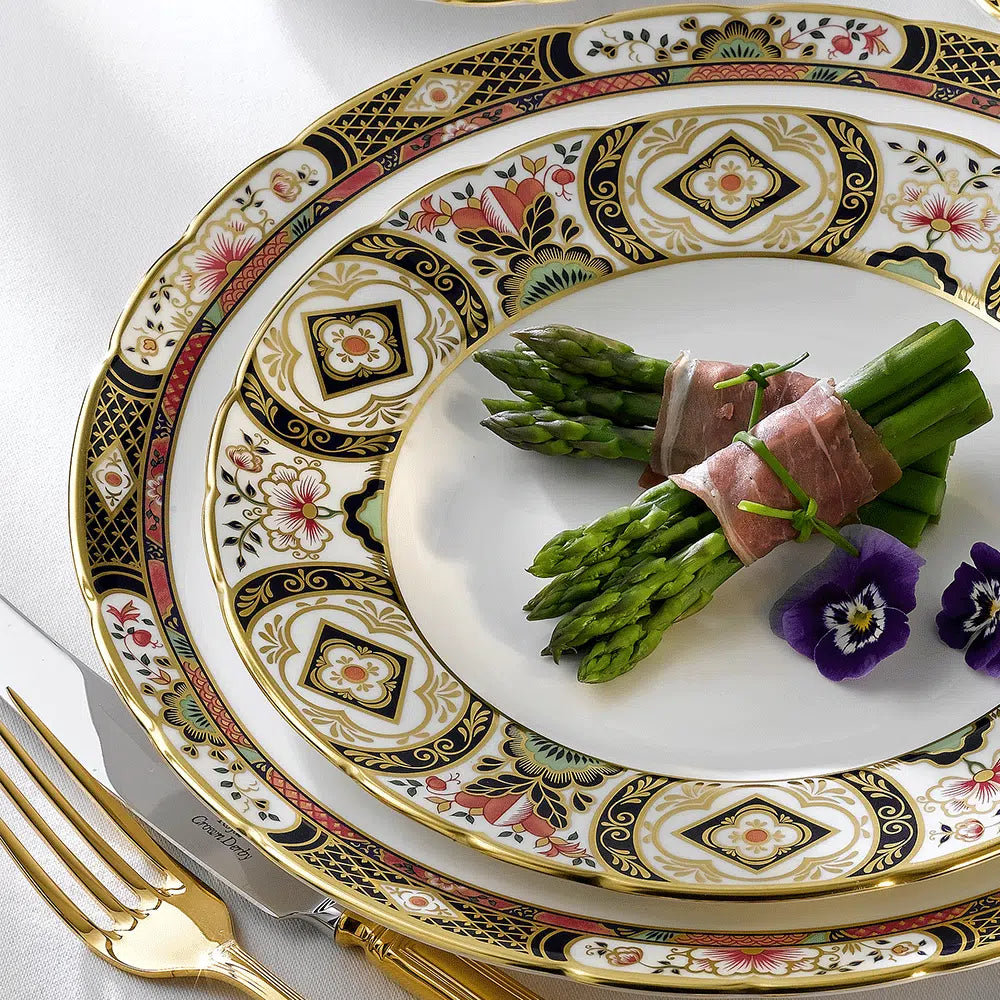 Top view of Chelsea Garden salad plate in fine bone china showcasing floral border with pink, green, and black motifs and 22 carat gold rim on white tablecloth