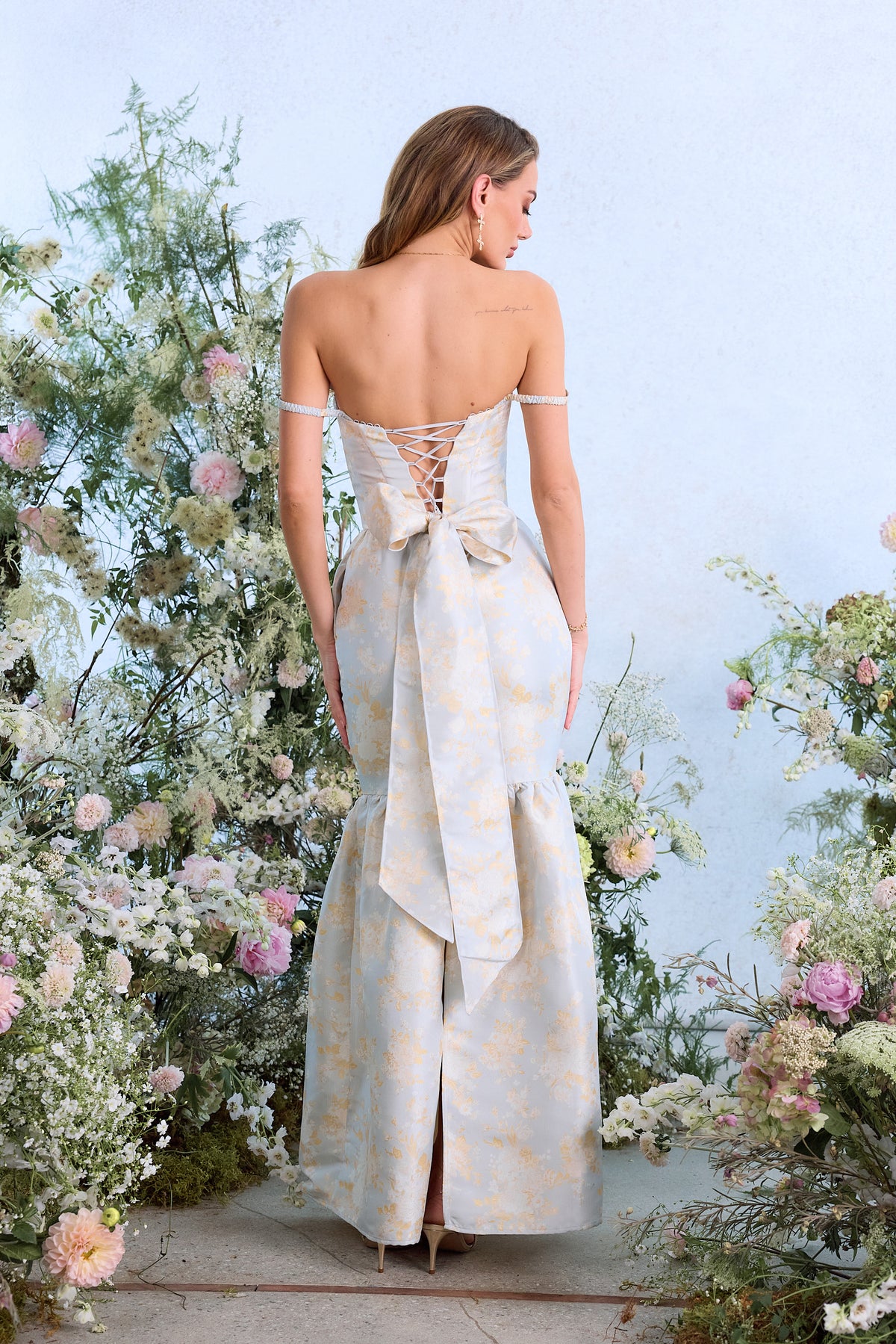 Rear view of Cherie Dress in Sky Windsor Brocade showing lace-up back, bow sash, and back slit
