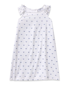 The Girls Twill Amelie Nightgown in Buzzing Bees by Petite Plume features ruffled shoulder straps and a simple A-line cut. Made from soft cotton, its white fabric with small blue floral patterns ensures comfort and elegance for a restful night.