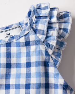 Close-up of a Petite Plume girls twill Amelie nightgown in royal blue gingham print, with ruffled edges and a visible tag inside. The sleepwear showcases stitching details and features alternating shades of blue in its classic check pattern.
