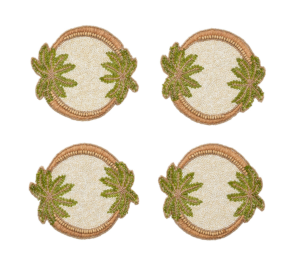 Front view of four Oasis Coasters in ivory, green and gold showcasing beaded palm tree motifs on a white background