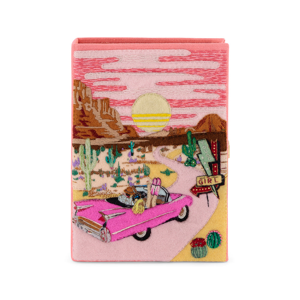 Front view of Wild and Free Book Clutch with embroidered desert, pink convertible, cacti, and GIRL sign on white background