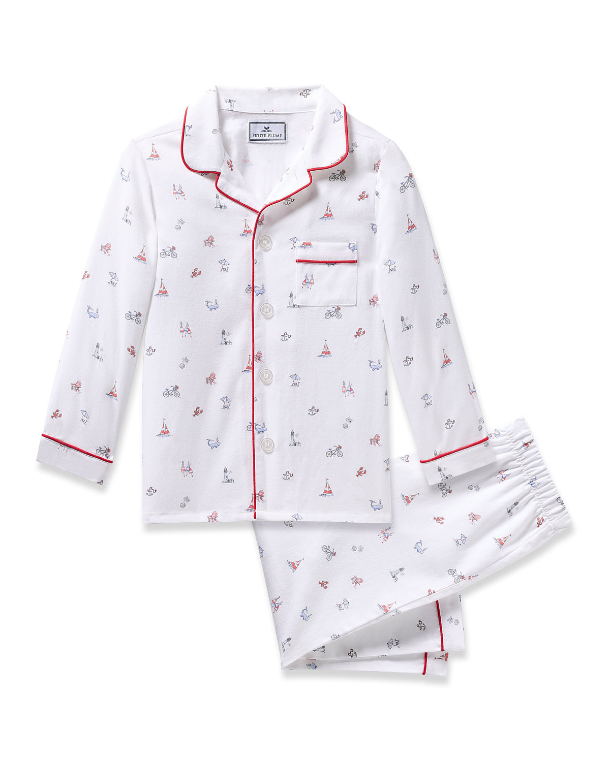 The Kids Twill Pajama in Coastal Charms by Petite Plume is flame-retardant, made from yarn-dyed cotton, and features a white design with red piping, adorned with small bicycle and Eiffel Tower prints. It includes a long-sleeve button-up top with a chest pocket and matching pants.