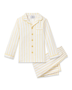 The Kids Twill Pajama in Sunny Stripe by Petite Plume is a yarn-dyed cotton two-piece set with yellow and white stripes. It includes a buttoned long-sleeve top with collar, pocket, yellow buttons, and matching pants with an elastic waistband.