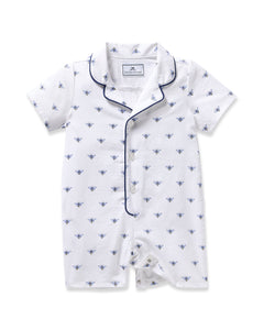 The Petite Plume Babys Twill Summer Romper features a charming bee pattern on brushed twill fabric. This white romper has short sleeves, a button-up front, and a collar with dark blue piping, providing soft comfort ideal for infants.