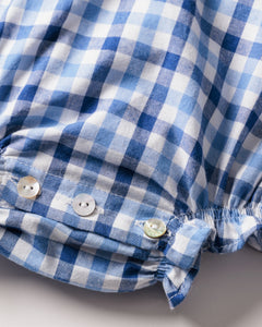 Close-up of the Babys Twill Ruffled Romper in Royal Blue Gingham by Petite Plume, featuring a gathered edge and two white buttons. The fabric showcases a luxurious blue and white gingham check pattern.
