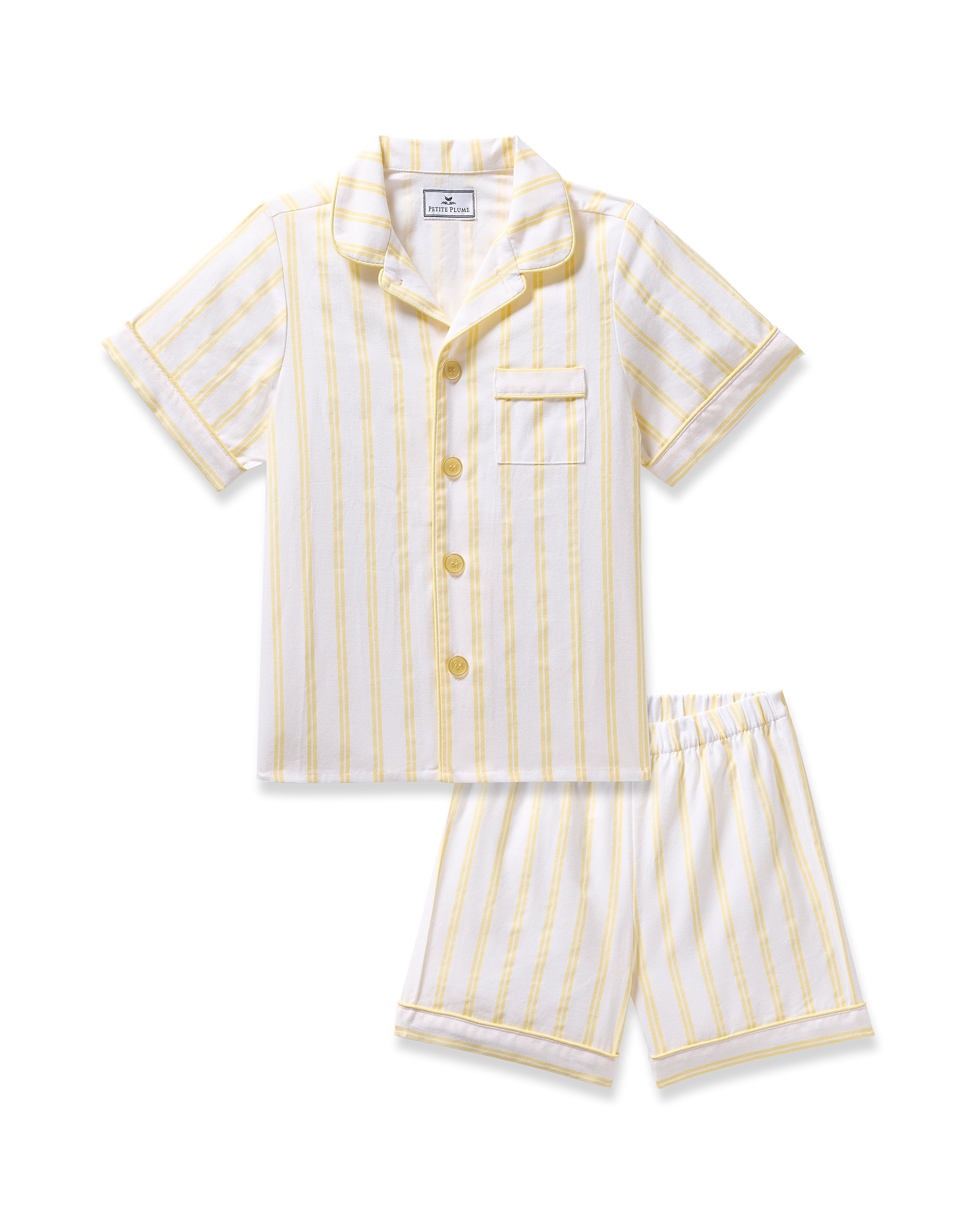 The Kids Twill Short Sleeve Short Set in Sunny Stripe by Petite Plume is a luxurious two-piece featuring a collar, pocket, button-down top with short sleeves, and shorts with an elastic waistband. The fabric is white with vertical yellow stripes for added style.