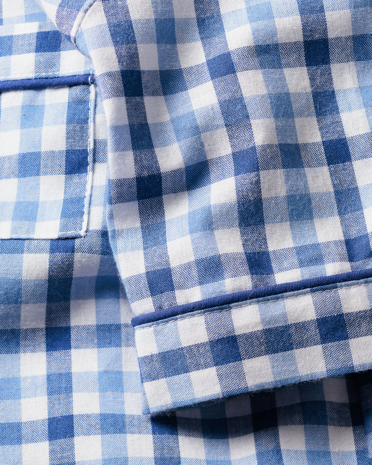 Close-up of Petite Plumes Kids Twill Pajama Short Set in Royal Blue Gingham, showcasing luxurious sleepwear with visible stitching and a rectangular pocket in a classic checkered pattern of small squares.