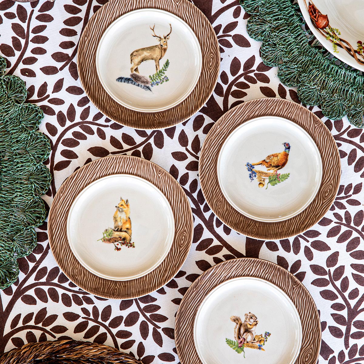 Overhead view of Forest Walk cocktail plate set of 4 with woodland animal illustrations and brown woodgrain rims