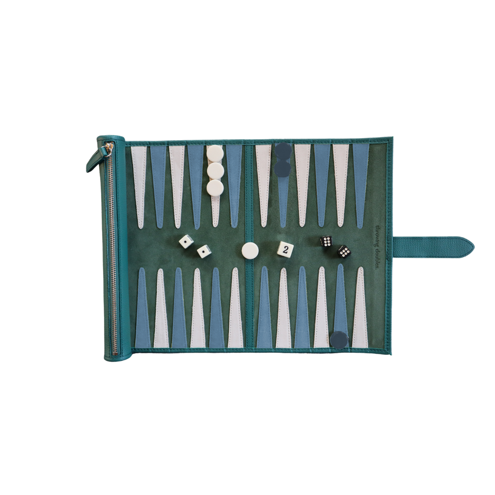 Top-down view of Travel Cyprus Backgammon Board with green suede playing field, blue-and-white points, checkers and dice