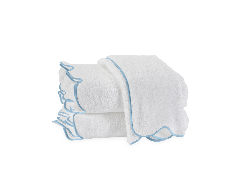 Front view of Cairo Scallop bath towel stack showcasing light blue scalloped trim on white terry cloth with white background