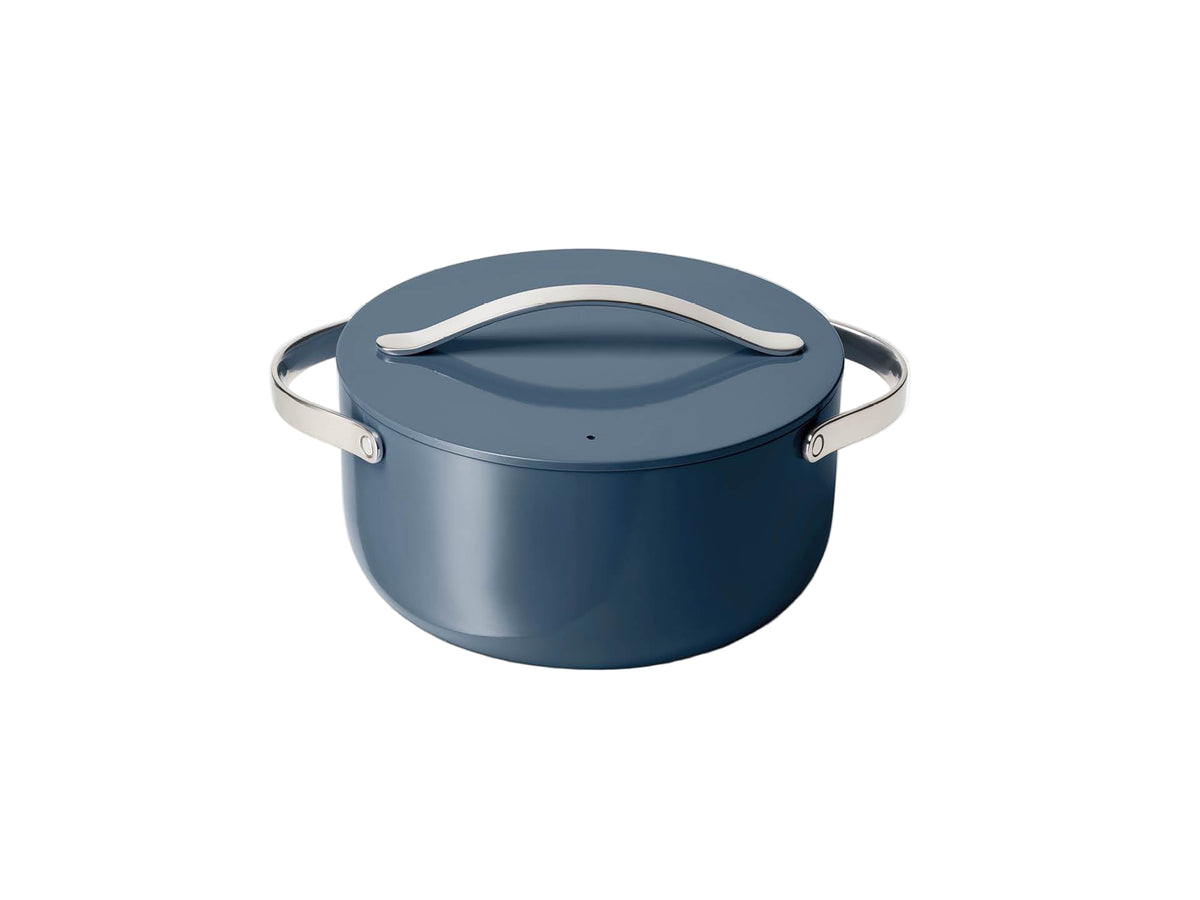 Front view of navy ceramic Dutch oven with lid showcasing stainless steel handles on white background