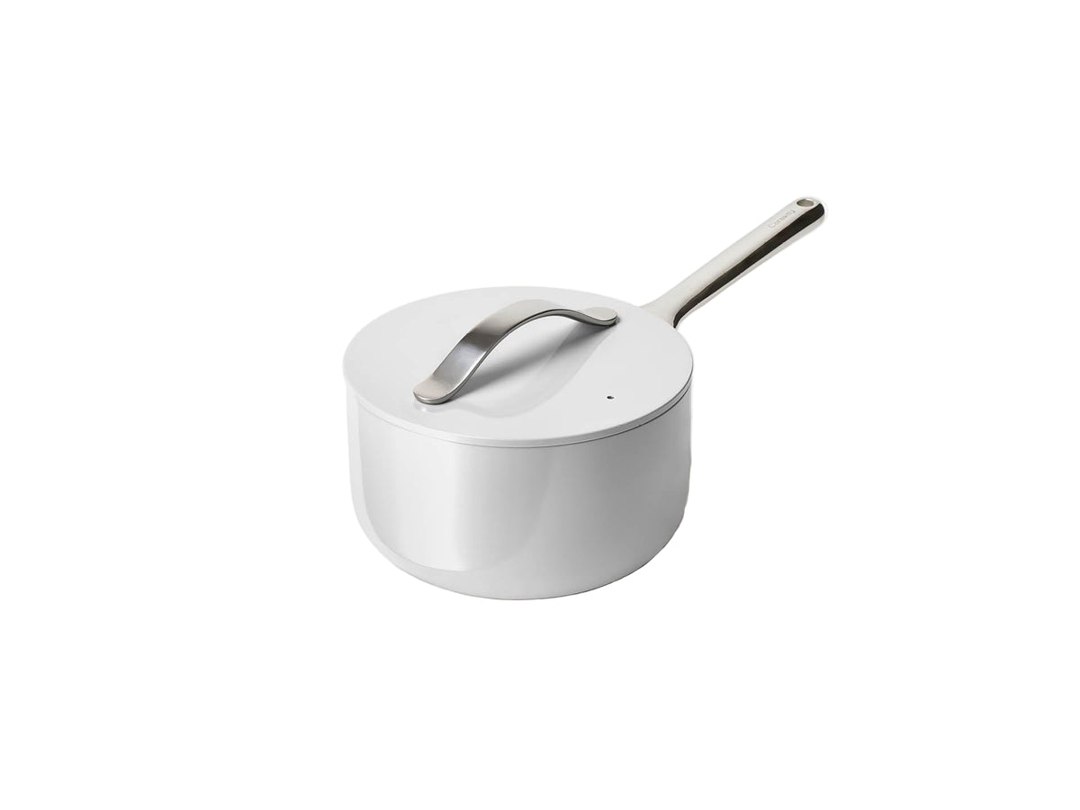 Angled view of 3-qt Caraway ceramic sauce pan with lid, gray nonstick finish and stainless handle on white