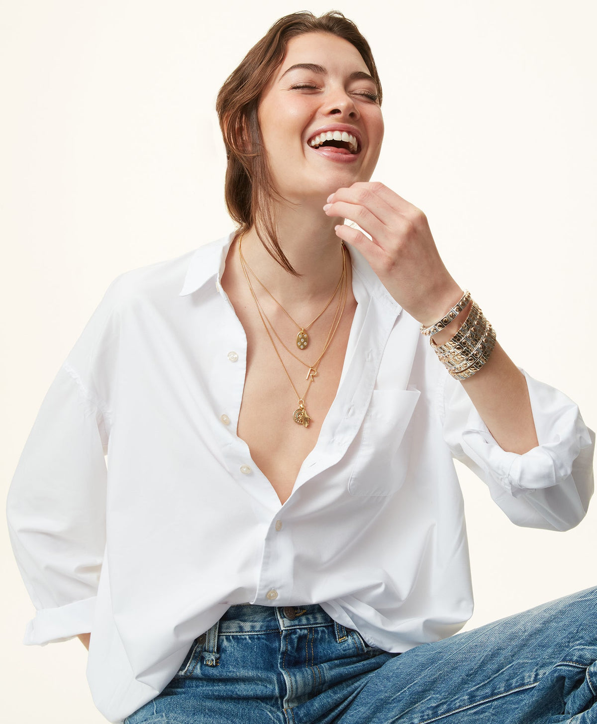 Close-up of The Stud Bracelet set of three on a model’s wrist showing mixed metal enamel stretch bracelets on a white shirt