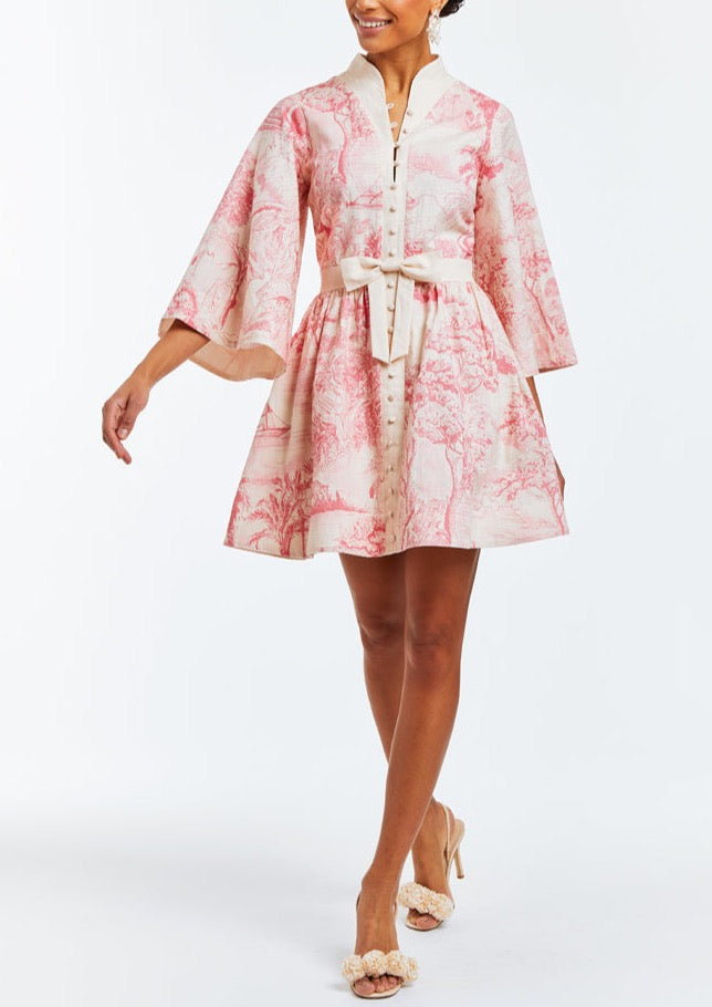 Linen mini dress with butterfly sleeves, hand pockets, and front bow detail. Featuring a mandarin collar and a pink toile print. 