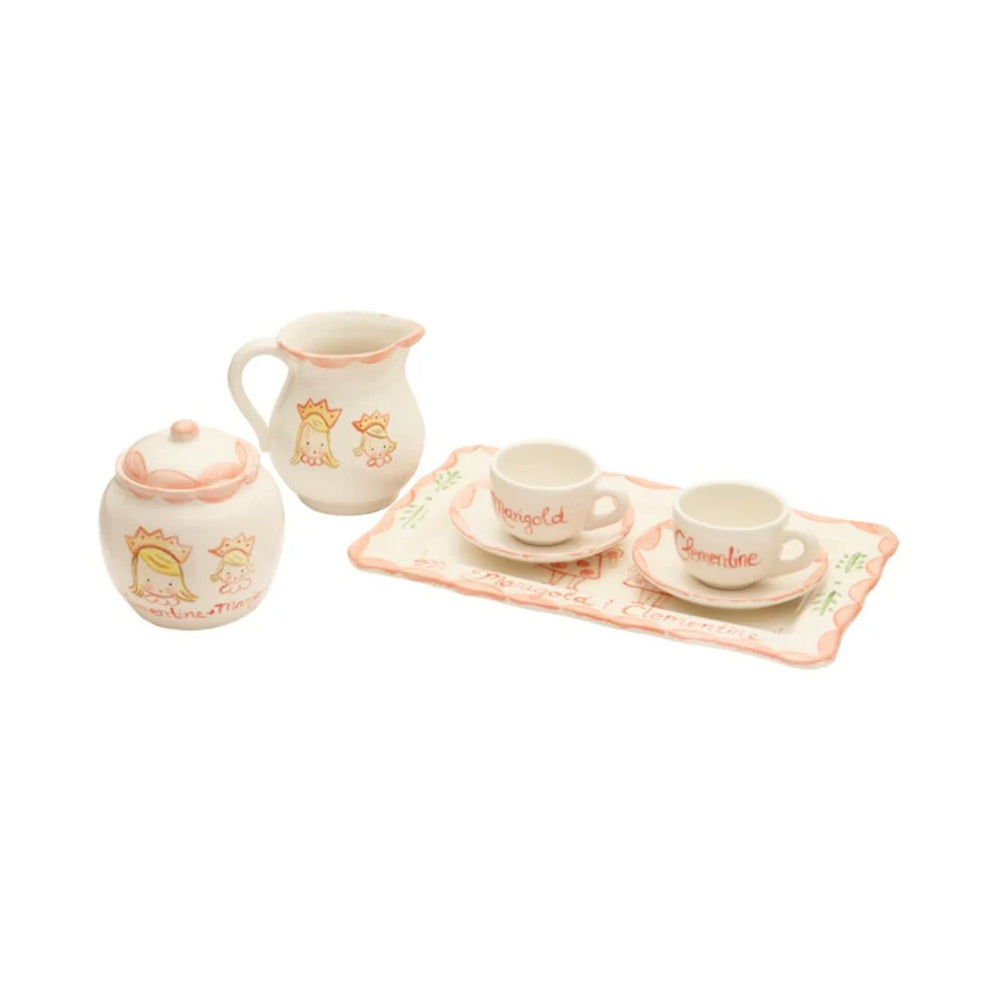 Angled view of personalized children’s tea set with hand-painted princess illustrations and handwritten names on cups and tray