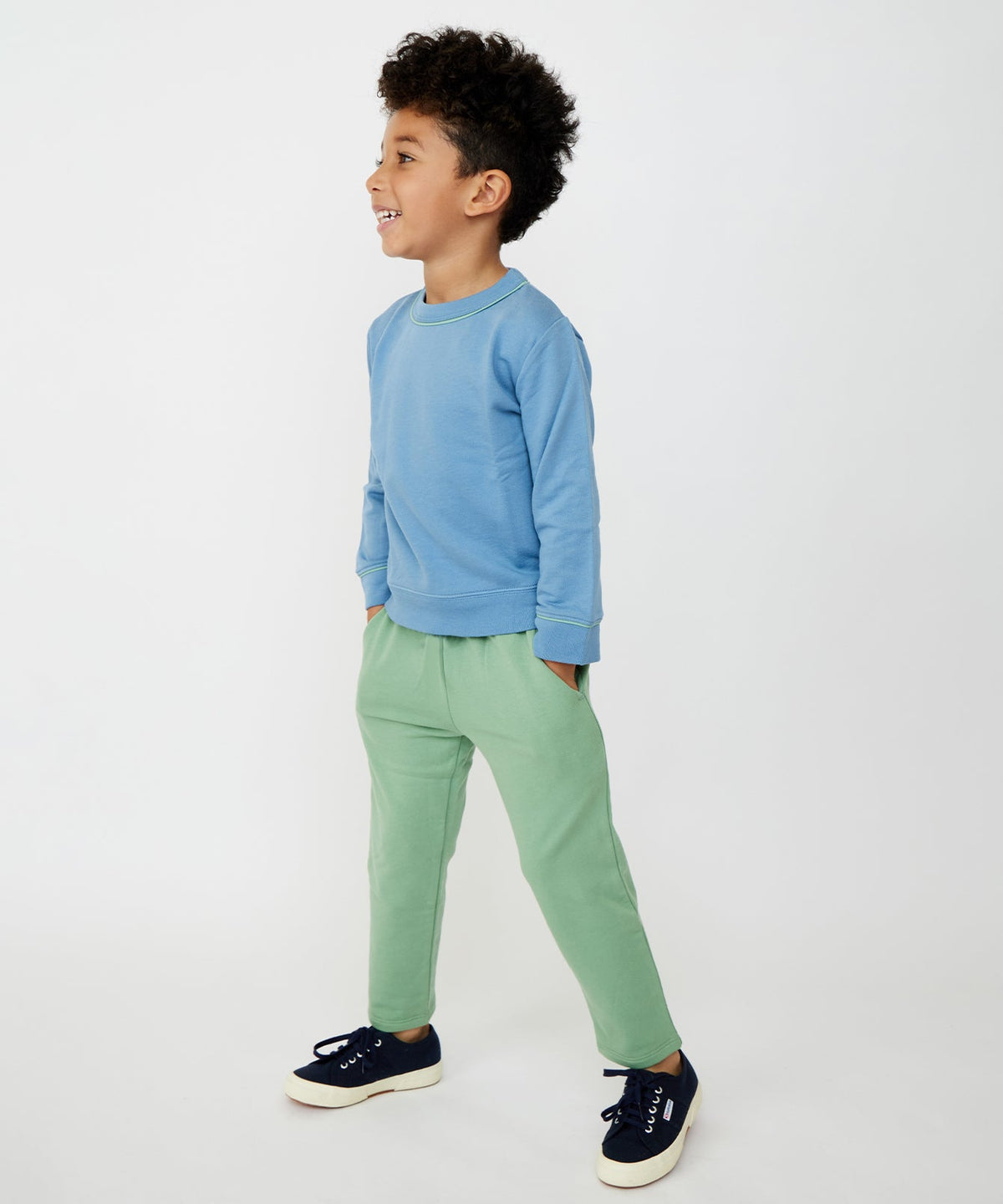 Three-quarter view of Chris Jogger pants in basil on child model showing elastic flex-fit waist and front pockets on white background