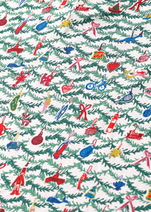 Close-up of Oh Christmas Tree block print children’s pajamas showcasing colorful ornaments and evergreen branches on white fabric