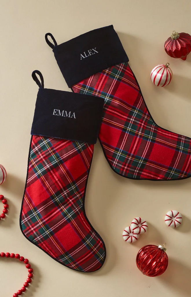 Top view of two Imperial Tartan Christmas stockings with navy velour cuffs embroidered EMMA and ALEX on cream background