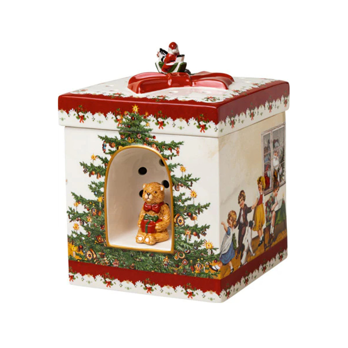 Three-quarter view of square porcelain Christmas box with red bow lid, hand-painted children and tree motifs, front teddy