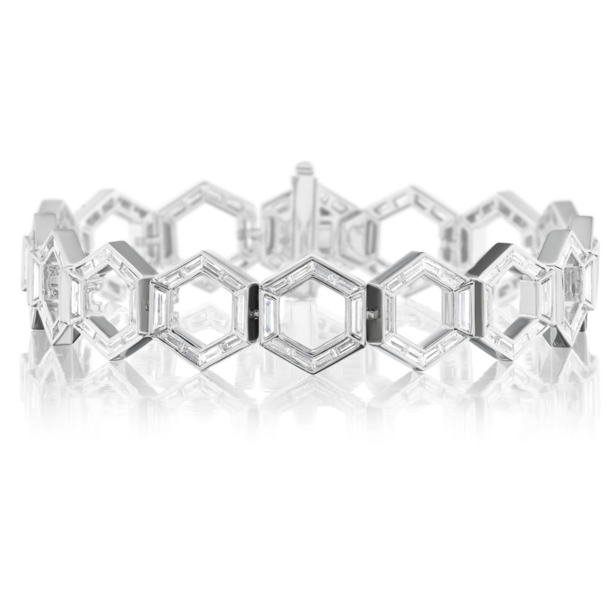 The Chrysler Hexagon Diamond Bracelet in White Gold features interconnected hexagonal links set with baguette diamonds totaling 4.79TCW, elegantly displayed on a reflective white surface.