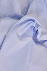 The Clarke Shirt has a cropped, boxy fit, a collared neckline, a button front and wide sleeves.
