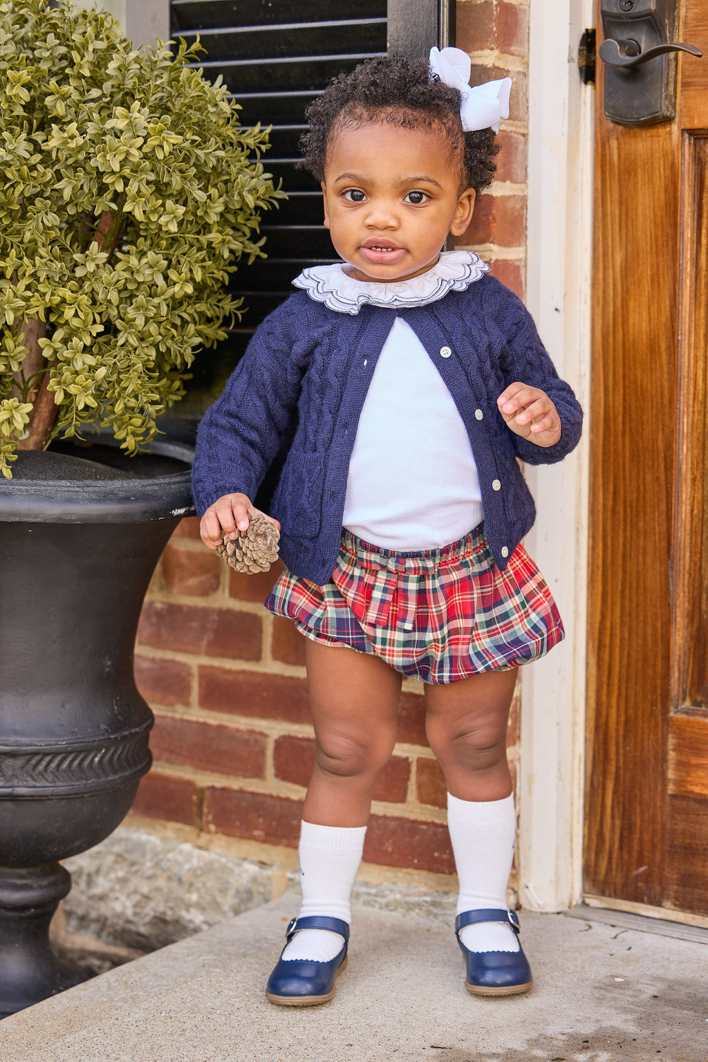Little english classic children's clothing, cashmere blend cardigan in navy,  double london blouse with navy stitching on collar, bow bloomers in middleburg plaid, knee high socks with navy bow motif, fall outfit for little girl  