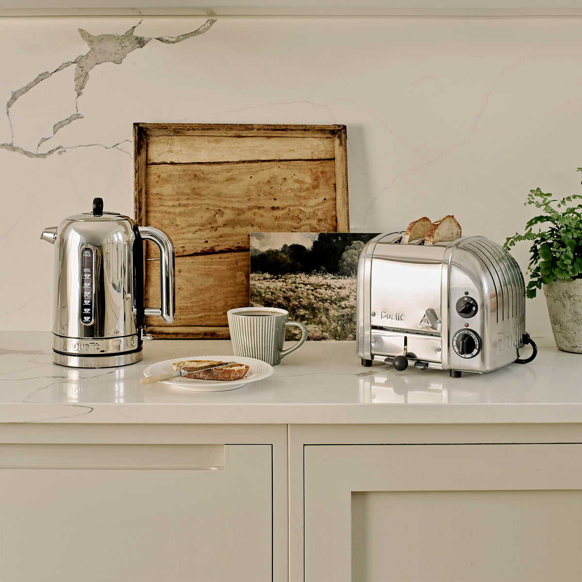 Three-quarter view of 2 Slot Classic Toaster in Polished Chrome showcasing two toasted slices with a kitchen countertop background