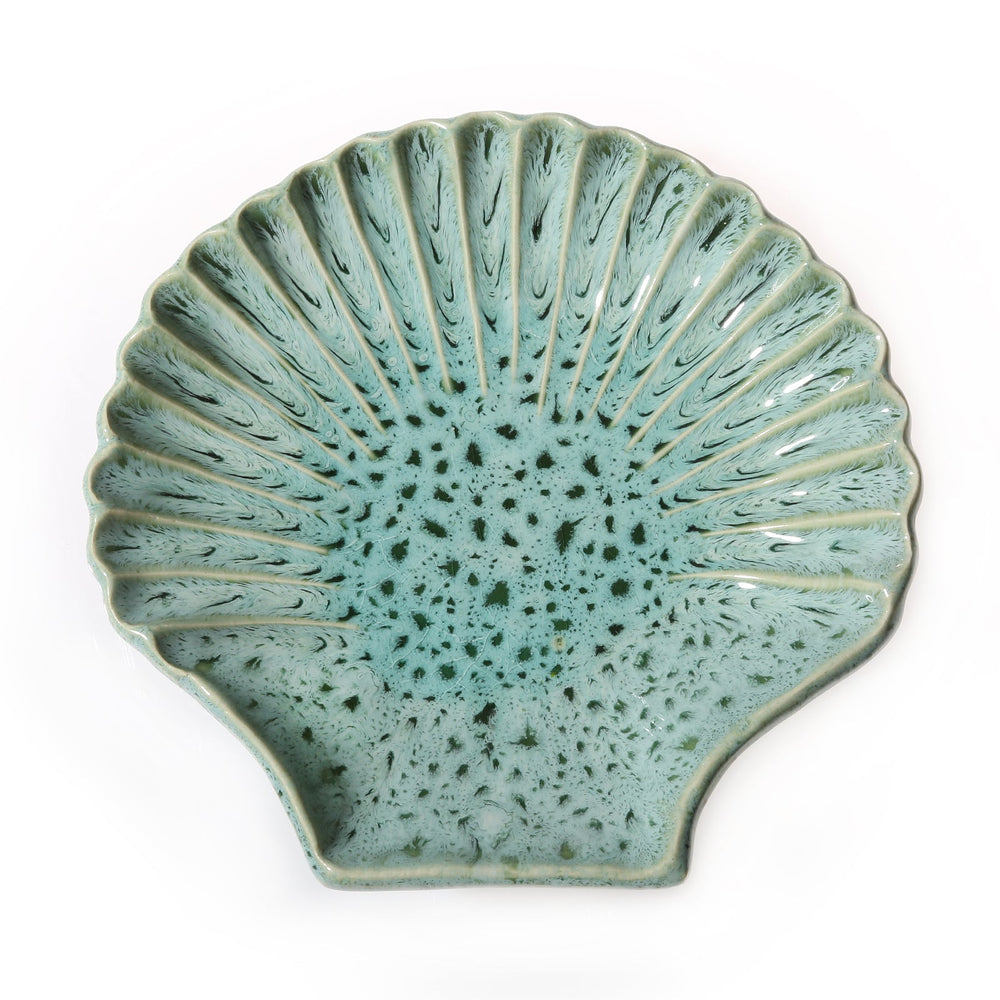 Top view of Concha Medium ceramic shell plate showcasing seafoam speckled glaze and scalloped ridged edge on white background