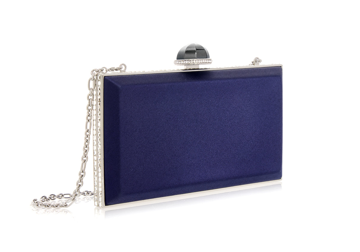 Three-quarter view of Skylar Satin Handbag in navy showcasing rectangular satin body, silver crystal-framed push-lock and removable chain on white background