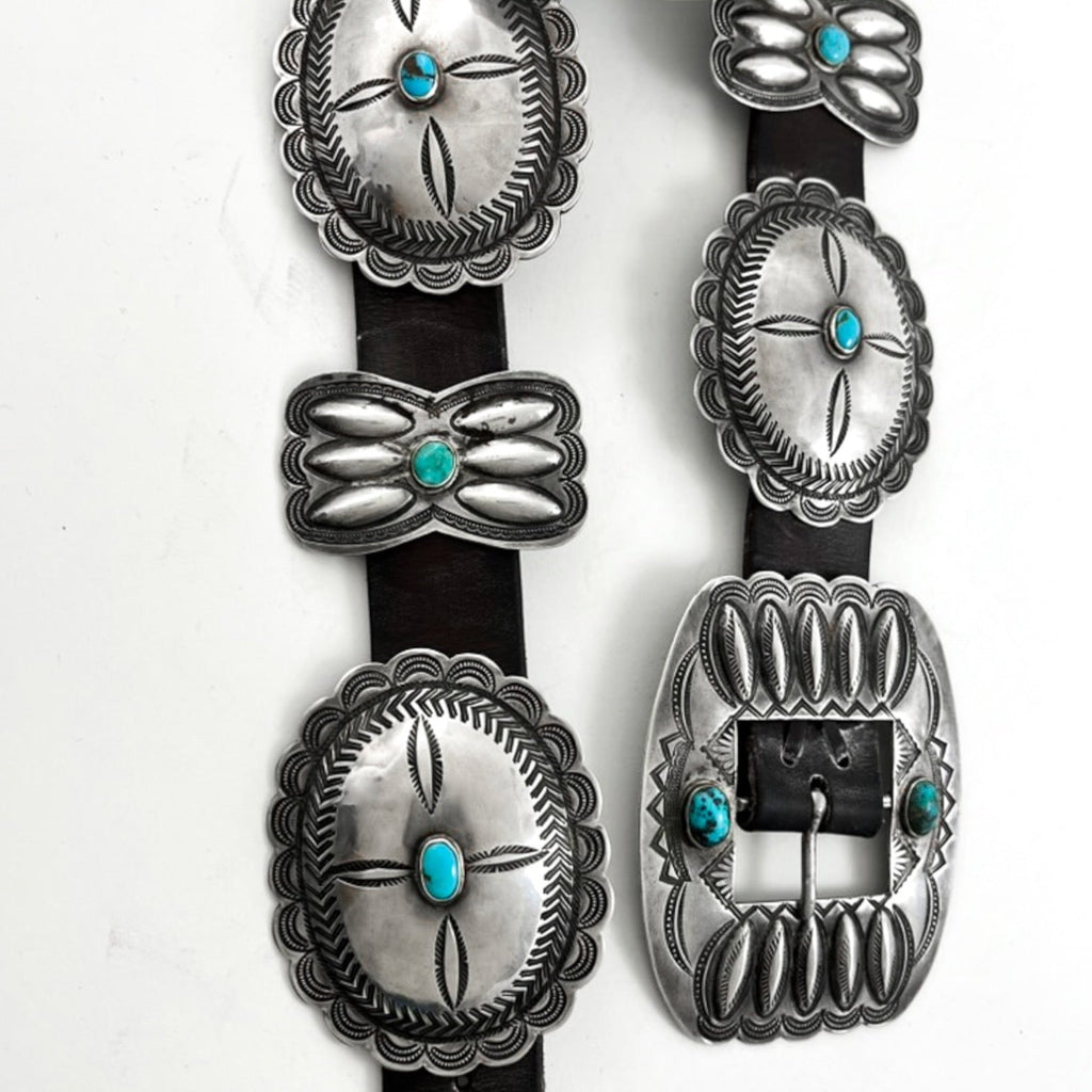 Close-up of Vintage Concho Belt showcasing sterling silver conchos, turquoise stones, and butterfly details on a white background