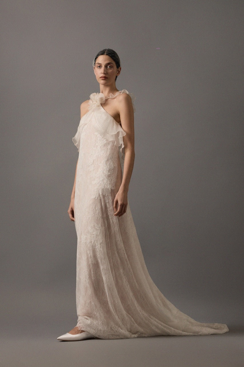 Three-quarter front view of Penelope gown in off white/nude with halter neckline, organza ruffle and flower, Chantilly lace