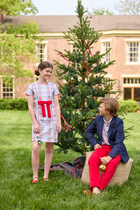 Little English classic children's clothing. Girls A-line dress in red and green plaid with red bow and red piping detail for the holidays.  Boys Douglas Plaid button down shirt with red corduroy pants and navy wool blazer.