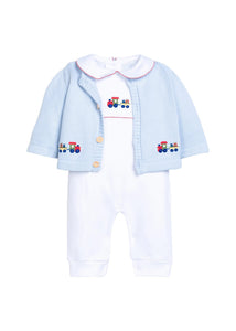 Little English traditional children's clothing.  Light blue cotton cardigan with crocheted holiday trains on either side and in back for baby boys. Layered over white pima cotton playsuit with red picot trim and holiday train crochet at the center chest